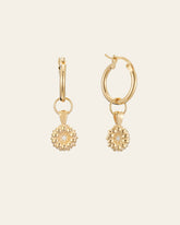 The CAMELLIA Elsa Daisy Diamond Earrings are meticulously handcrafted in New York, featuring spherical, beaded pendants hanging from gold hoops.